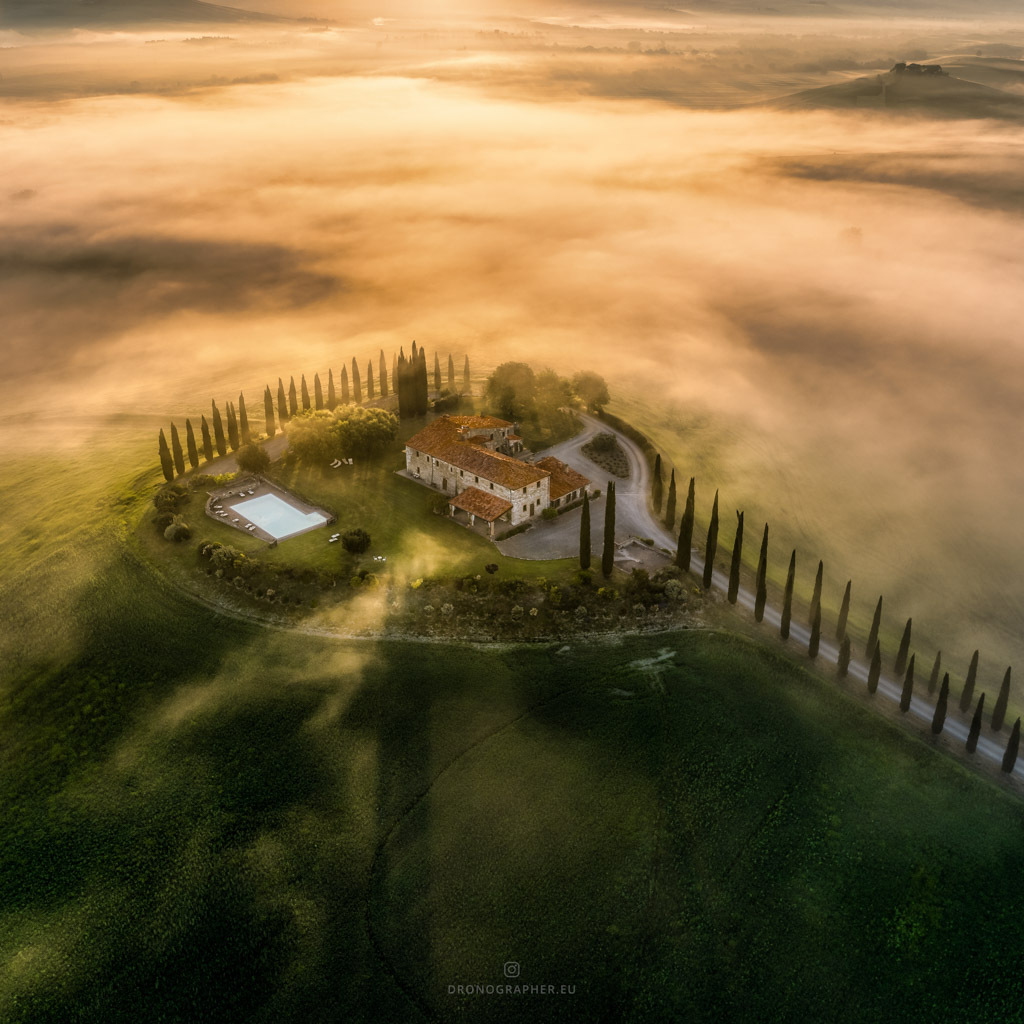 An aerial photo of a villa in Tuscany, surrounded by fog.